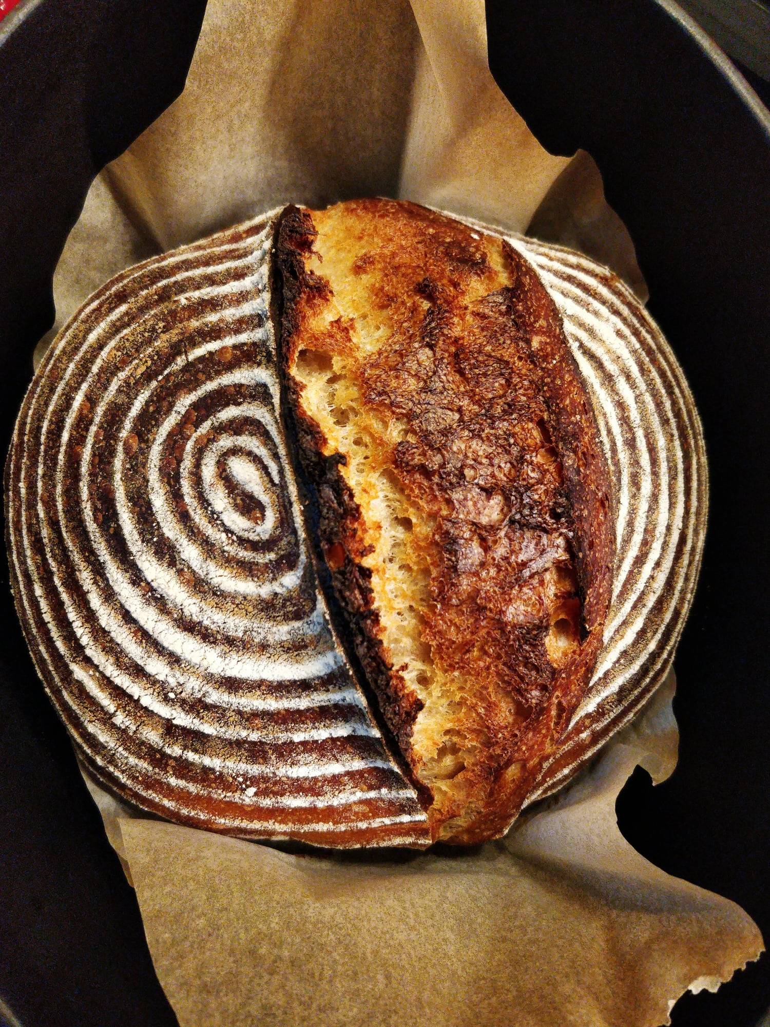 A golden sourdough loaf with a spiral score, fresh from the oven.